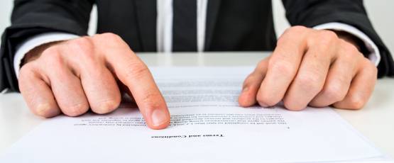 Closeup of an injury lawyer explaining a document to an injured client.