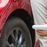 Person documenting vehicle damage after a car accident in Texas for a personal injury claim