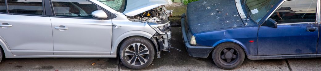 Two vehicles involved in a collision showing front-end damage, representing a partially at-fault accident in Texas