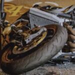 Motorcycle lying on the road after a crash with emergency response nearby in Texas