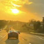 Vehicles driving on a highway at sunset during busy summer travel season in Texas