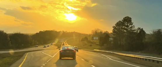 Vehicles driving on a highway at sunset during busy summer travel season in Texas