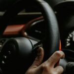 Driver holding steering wheel while driving on a road in Texas during summer travel season