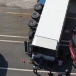 Aerial view of multiple 18-wheelers involved in a collision at a roadway intersection.
