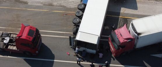 Aerial view of multiple 18-wheelers involved in a collision at a roadway intersection.