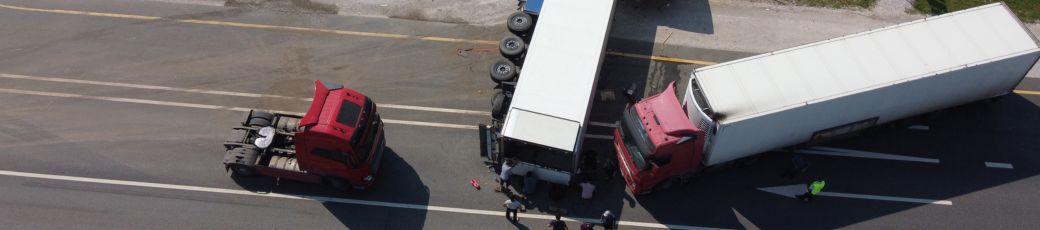 Aerial view of multiple 18-wheelers involved in a collision at a roadway intersection.