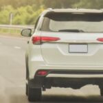SUV driving on a curved roadway during warm summer weather in Texas.