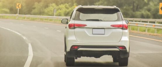 SUV driving on a curved roadway during warm summer weather in Texas.