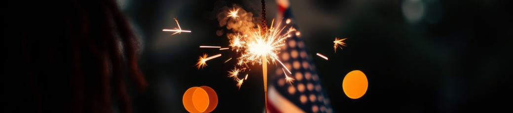 Person holding a lit sparkler during a Fourth of July celebration, highlighting Independence Day safety for families in McAllen and the Rio Grande Valley.