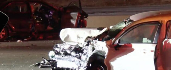 A person holding a smartphone in front of the scene of a serious car accident, illustrating the importance of being cautious about social media posts during a personal injury case in McAllen, Texas.