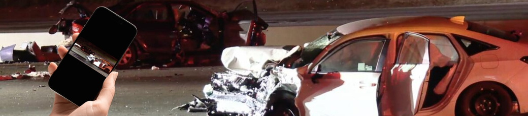 A person holding a smartphone in front of the scene of a serious car accident, illustrating the importance of being cautious about social media posts during a personal injury case in McAllen, Texas.