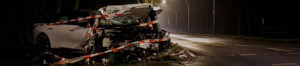 Severely damaged vehicle at a nighttime car accident scene