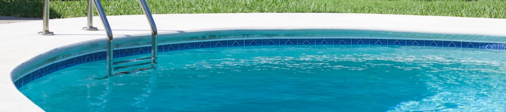 Residential swimming pool with ladder and surrounding grass