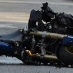 Damaged motorcycle lying on the road after a serious traffic accident