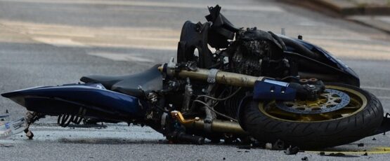 Damaged motorcycle lying on the road after a serious traffic accident